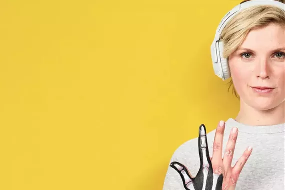 Kůže a klouby - mladá žena ukazuje ruku s kostmi jako smbol revmatologie